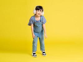 full body image of beautiful asian baby girl on yellow background photo