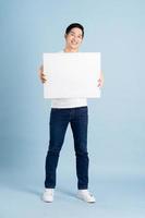 portrait of asian man posing on blue background photo