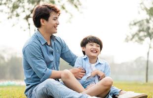 image of an asian father and son having fun in the park photo