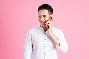 portrait of asian man posing on pink background photo