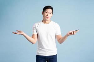 portrait of asian man posing on blue background photo