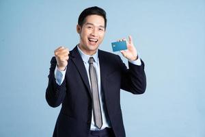 portrait of asian businessman wearing suit on blue background photo