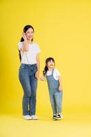 imagen de madre e hija asiáticas posando sobre un fondo amarillo foto