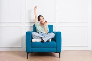 image of young Asian girl sitting on sofa at home photo