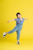 full body image of beautiful asian baby girl on yellow background photo