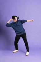 image of asian man wearing virtual reality glasses on purple background photo