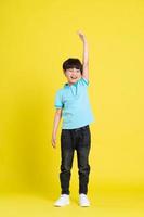 full body image of asian boy posing on yellow background photo