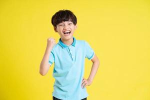 portrait of an asian boy posing on a yellow background photo