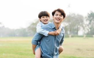 image of an asian father and son having fun in the park photo