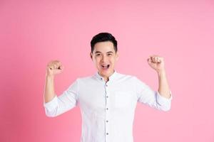 portrait of asian man posing on pink background photo