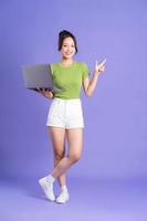 full body image of beautiful asian girl posing on pink background photo