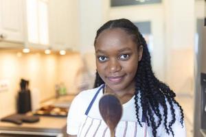 Young African woman is talking selfie in the kitchen photo