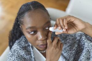 mujer utilizando ojo gota, mujer goteante ojo lubricante a tratar seco ojo o alergia, enfermo mujer tratando globo ocular irritación o inflamación mujer sufrimiento desde irritado ojo, óptico síntomas foto