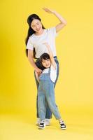 imagen de madre e hija asiáticas posando sobre un fondo amarillo foto