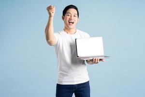 portrait of asian man posing on blue background photo