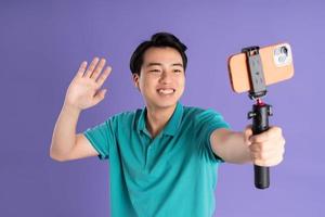 retrato de asiático hombre posando en púrpura antecedentes foto