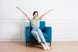 image of young Asian girl sitting on sofa at home photo