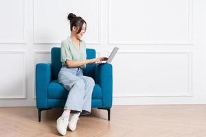 image of young Asian girl sitting on sofa at home photo