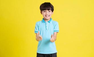 portrait of an asian boy posing on a yellow background photo