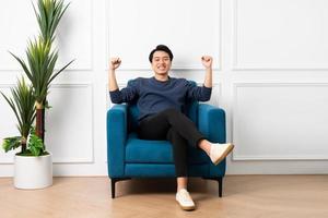 portrait of asian man sitting on sofa at home photo