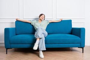 image of young Asian girl sitting on sofa at home photo