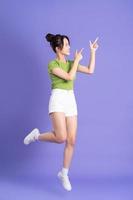 full body image of beautiful asian girl posing on pink background photo