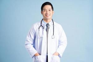 asiático masculino médico retrato en azul antecedentes foto