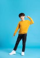 full body image of asian boy posing on blue background photo