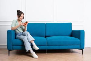 image of young Asian girl sitting on sofa at home photo