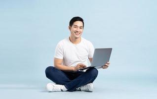 portrait of asian man posing on blue background photo