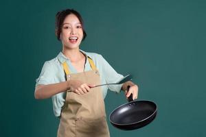 Asian woman wearing apron and holding a pan photo