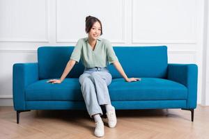 image of young Asian girl sitting on sofa at home photo