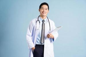 Asian male doctor portrait on blue background photo