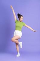 full body image of beautiful asian girl posing on pink background photo