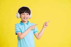 portrait of an asian boy posing on a yellow background photo