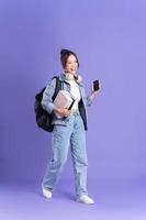 retrato de un hermosa asiático Chica de escuela vistiendo un mochila en un púrpura antecedentes foto