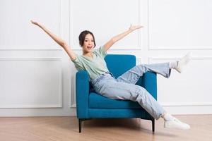 image of young Asian girl sitting on sofa at home photo