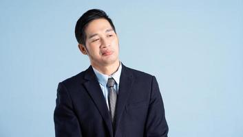 portrait of asian businessman wearing suit on blue background photo