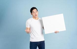 portrait of asian man posing on blue background photo