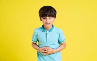 retrato de un asiático chico posando en un amarillo antecedentes foto