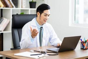 asiático masculino médico retrato sentado a trabajo foto