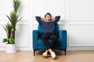 portrait of asian man sitting on sofa at home photo