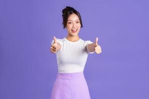 Portrait of a beautiful Asian woman posing on a purple background photo