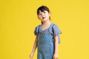 portrait of a beautiful asian girl, isolated on yellow background photo