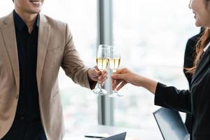 group of Asian business people holding glasses of wine to celebrate new year photo