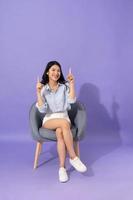 image of girl sitting on sofa  isolated on purple background photo