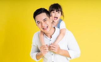 image of two happy father and daughter playing, isolated on yellow background photo