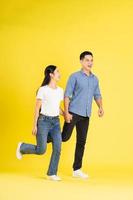 full body image of asian couple posing on yellow background photo
