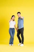 full body image of asian couple posing on yellow background photo