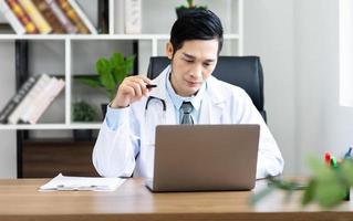 asiático masculino médico retrato sentado a trabajo foto